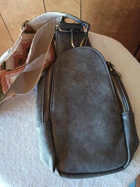 grey faux leather crossbody sling bag with a patterned fabric strap